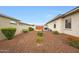 Low-maintenance backyard with gravel, privacy hedges, and gated access, offering a secure and simple outdoor space at 2735 E King Bird Dr, Gilbert, AZ 85297