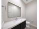 Modern powder room featuring large mirror, modern fixtures, and dark vanity at 2735 E King Bird Dr, Gilbert, AZ 85297