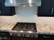 Gourmet kitchen boasts a WOLF six-burner gas cooktop, stylish black cabinetry and granite counters at 2735 E King Bird Dr, Gilbert, AZ 85297