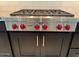 Close-up of the WOLF six-burner gas cooktop, complete with stylish black cabinetry at 2735 E King Bird Dr, Gilbert, AZ 85297