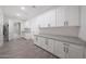 Spacious laundry room featuring wood-look tile flooring, white cabinets, and granite countertops at 2735 E King Bird Dr, Gilbert, AZ 85297