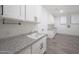 Bright laundry room with white cabinetry, granite counters, modern fixtures, and tile flooring at 2735 E King Bird Dr, Gilbert, AZ 85297