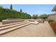 Inviting outdoor space featuring a tiered patio, outdoor fireplace, and lush landscaping at 2735 E King Bird Dr, Gilbert, AZ 85297