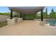 Outdoor kitchen with stainless steel grill under a pergola next to a pool and privacy landscaping at 2735 E King Bird Dr, Gilbert, AZ 85297