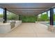 Outdoor kitchen with stainless steel grill beneath a pergola, situated next to a pool with verdant privacy landscaping at 2735 E King Bird Dr, Gilbert, AZ 85297
