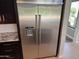 A side-by-side stainless steel KitchenAid refrigerator is accented by modern dark cabinetry at 2735 E King Bird Dr, Gilbert, AZ 85297