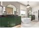 Elegant bathroom showcasing modern green cabinets, dual vanity, a standalone tub, and stylish mirrors at 2851 E Alexander Ct, Gilbert, AZ 85298