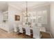 Bright dining room with white chairs, a wooden table, shuttered windows, and a chandelier for a modern look at 2851 E Alexander Ct, Gilbert, AZ 85298