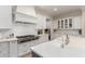This bright kitchen features white cabinets, stainless steel appliances, a large island, and tile backsplash at 2851 E Alexander Ct, Gilbert, AZ 85298