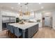 A spacious kitchen featuring white cabinets, stainless steel appliances, an island, and hanging gold pendant lights at 2851 E Alexander Ct, Gilbert, AZ 85298
