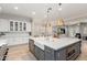 Bright kitchen boasts a large island with a white farmhouse sink, stainless steel appliances, and white cabinets at 2851 E Alexander Ct, Gilbert, AZ 85298