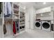 Bright laundry area with built-in shelving, closet storage, and modern side-by-side washer and dryer at 2851 E Alexander Ct, Gilbert, AZ 85298