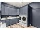 Well-organized laundry room with gray cabinetry, countertop space, and modern washer and dryer units at 2851 E Alexander Ct, Gilbert, AZ 85298
