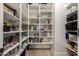 Walk-in pantry with white shelves stocked with various food items and organizational containers for ample storage at 2851 E Alexander Ct, Gilbert, AZ 85298