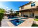 Gorgeous swimming pool with an attached spa, surrounded by elegant travertine tile and beautiful landscaping at 2851 E Alexander Ct, Gilbert, AZ 85298