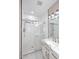 Well-lit bathroom features dual sinks, marble countertops and a glass-enclosed shower at 36950 W Mondragone Ln, Maricopa, AZ 85138