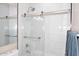Modern bathroom with marble tile, glass shower door, and chrome fixtures at 36950 W Mondragone Ln, Maricopa, AZ 85138
