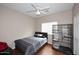 Cozy bedroom featuring a ceiling fan, window, and sleek hardwood floors at 36950 W Mondragone Ln, Maricopa, AZ 85138