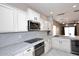 Bright modern kitchen with white cabinets, stainless steel appliances, and light countertops at 36950 W Mondragone Ln, Maricopa, AZ 85138