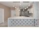 Modern kitchen with white cabinets, marble countertops, stainless steel appliances, and decorative lighting at 36950 W Mondragone Ln, Maricopa, AZ 85138