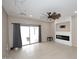 Bright living room with fireplace, ceiling fan and access to outdoor space through sliding glass doors at 36950 W Mondragone Ln, Maricopa, AZ 85138