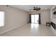 Spacious living room with light hardwood floors, fireplace, and sliding glass door to backyard at 36950 W Mondragone Ln, Maricopa, AZ 85138