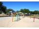 Vibrant splash pad with colorful arches and spray elements, surrounded by picnic shelters and lush greenery at 36950 W Mondragone Ln, Maricopa, AZ 85138