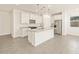 Bright kitchen with stainless appliances, white cabinets, granite countertops and a large island at 37125 W Prado St, Maricopa, AZ 85138