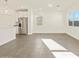 Bright open-concept living room with tiled floors and view of the kitchen and stainless refrigerator at 37125 W Prado St, Maricopa, AZ 85138