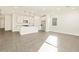 Bright open-concept living room with tiled floors and view of the island kitchen with pendant lighting at 37125 W Prado St, Maricopa, AZ 85138