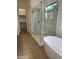 Bathroom including glass shower, tub, tile flooring and adjacent walk-in closet at 3738 E Rochelle Cir, Mesa, AZ 85213