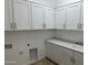 Well-organized laundry room with white cabinets, a sink, and ample counter space, making chores a breeze at 3738 E Rochelle Cir, Mesa, AZ 85213
