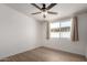 A well-lit bedroom with wood-look floors, a ceiling fan, and a window with neutral curtains at 3828 W Townley Ave, Phoenix, AZ 85051