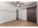 The bright bedroom has wood-look floors, a ceiling fan, barn door, and an adjacent bathroom at 3828 W Townley Ave, Phoenix, AZ 85051