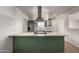 A modern kitchen features green cabinets, stainless steel appliances, and a spacious island with a cooktop at 3828 W Townley Ave, Phoenix, AZ 85051