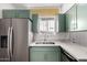 The kitchen features stainless steel appliances and green cabinetry at 3828 W Townley Ave, Phoenix, AZ 85051