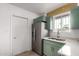 A kitchen has stainless steel appliances, green cabinets and white countertops at 3828 W Townley Ave, Phoenix, AZ 85051