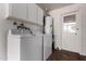 A well-equipped laundry room with a washer, dryer, storage cabinets, and an exterior door at 3828 W Townley Ave, Phoenix, AZ 85051