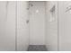 The all-white tiled shower features a rainfall showerhead and mosaic tile floor at 3828 W Townley Ave, Phoenix, AZ 85051
