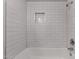 The remodeled shower features white subway tile and a convenient niche for storing bathing essentials at 3828 W Townley Ave, Phoenix, AZ 85051