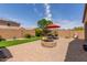 Beautiful backyard offers a brick fire pit, outdoor seating area, lush lawn and privacy wall at 41342 W Elm Dr, Maricopa, AZ 85138
