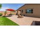 Backyard area showcases a brick fire pit, outdoor seating under an umbrella, and well-maintained turf at 41342 W Elm Dr, Maricopa, AZ 85138
