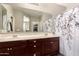 Bathroom featuring a double sink vanity and a large mirror reflecting the open doorway and closet at 41342 W Elm Dr, Maricopa, AZ 85138