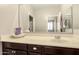 Bright bathroom featuring a dark wood vanity and a light countertop with sink, faucet, and mirror at 41342 W Elm Dr, Maricopa, AZ 85138
