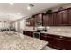 Modern kitchen with granite countertops, stainless steel appliances, and dark wood cabinetry at 41342 W Elm Dr, Maricopa, AZ 85138