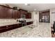 Spacious kitchen featuring stainless steel appliances, granite countertops, and dark wood cabinets at 41342 W Elm Dr, Maricopa, AZ 85138