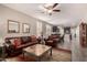 Spacious living room with natural light, wood flooring, and a seamless open-concept to the kitchen at 41342 W Elm Dr, Maricopa, AZ 85138