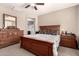 A spacious main bedroom featuring wood furniture, soft lighting, and a ensuite bathroom at 41342 W Elm Dr, Maricopa, AZ 85138