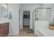 Bright bathroom featuring a soaking tub, glass enclosed shower, and walk-in closet at 4273 S Red Rock St, Gilbert, AZ 85297