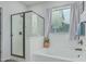 Bright bathroom featuring large soaking tub and glass enclosed shower with black hardware at 4273 S Red Rock St, Gilbert, AZ 85297